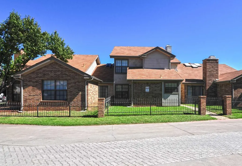 a large brick house with a black fence