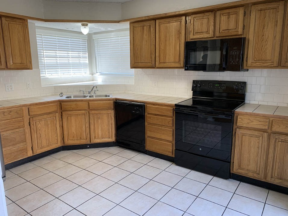 a kitchen with black appliances and wooden cabinets