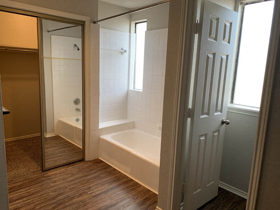 a bathroom with a tub and a shower and a door
