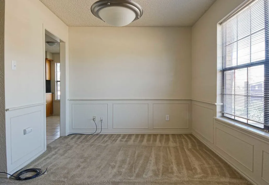 an empty living room with white walls and a large window