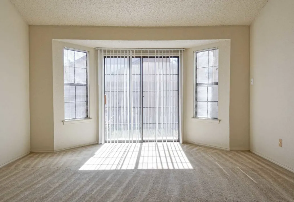 an empty living room with a sliding glass door