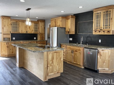A kitchen with wooden cabinets and a granite countertop.