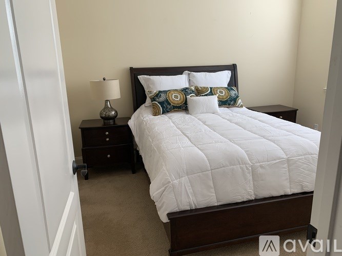 A bedroom with a bed, nightstand, and lamp.