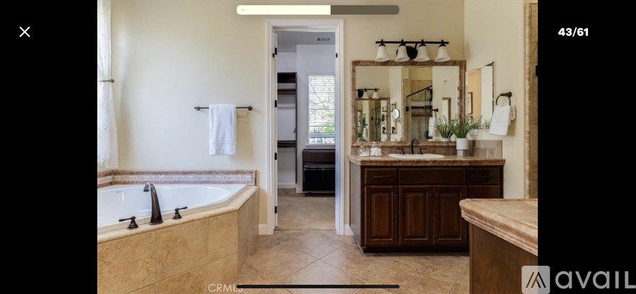 A bathroom with a tub, sink, and mirror.