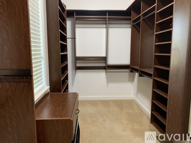 A room with a desk and a large window with blinds.