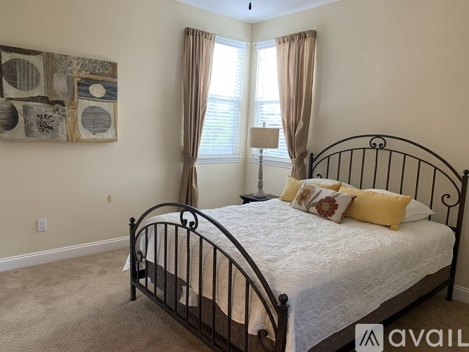 A bedroom with a large bed and a painting on the wall.