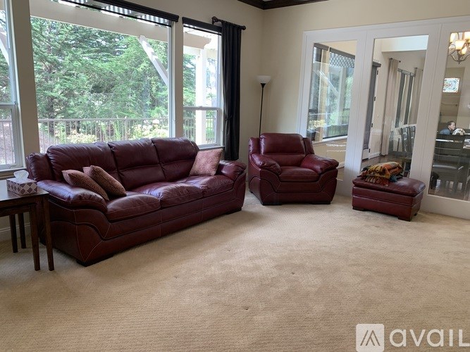 A living room with a red couch and chair.