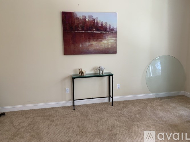 A room with a table and a painting on the wall.