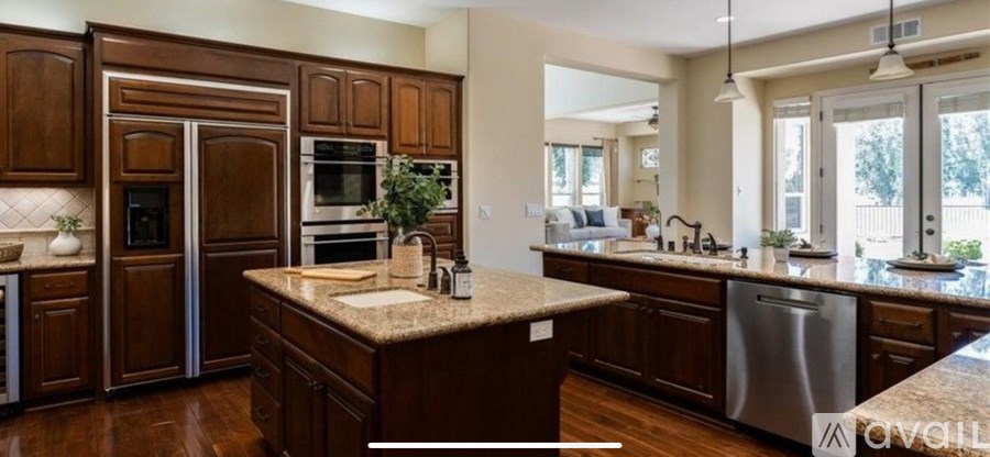 A kitchen with brown cabinets and a granite countertop.