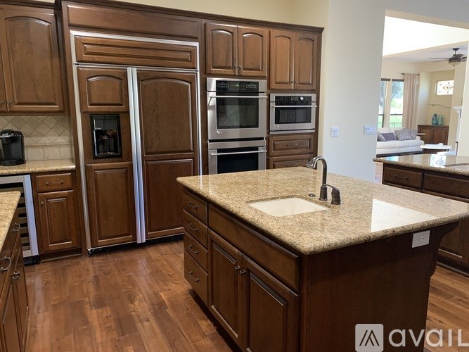 A kitchen with wooden cabinets and a granite countertop.