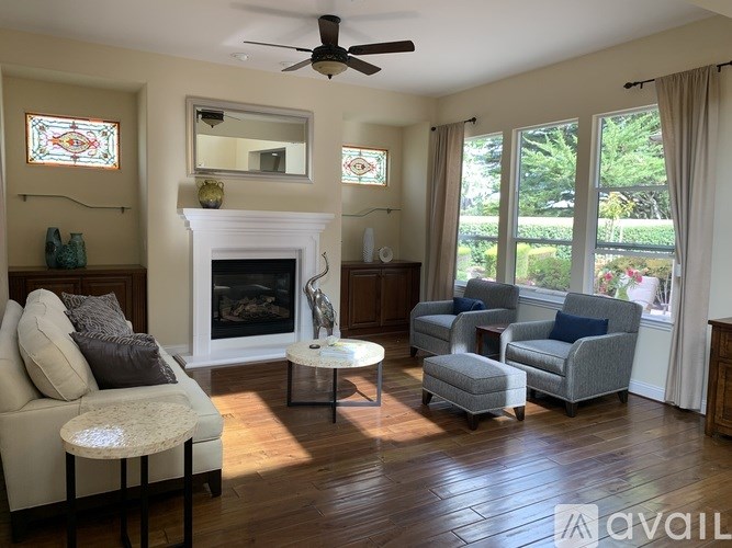 A living room with a fireplace and a grey couch.
