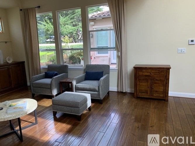 A living room with a sofa, armchairs, ottoman, and a coffee table.