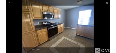 A kitchen with wooden cabinets and black appliances.