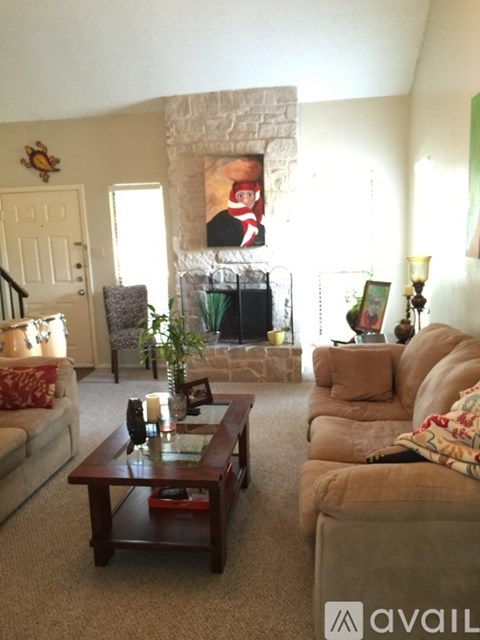 A living room with a fireplace and a painting of a man on the wall.