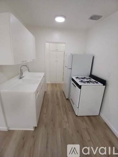 A small kitchen with a sink, refrigerator, and a stove top oven.