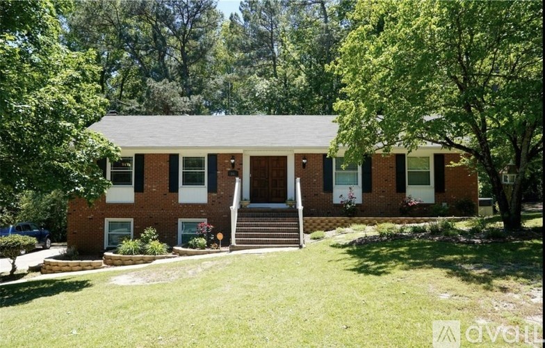 A house with a front yard and trees in the background.