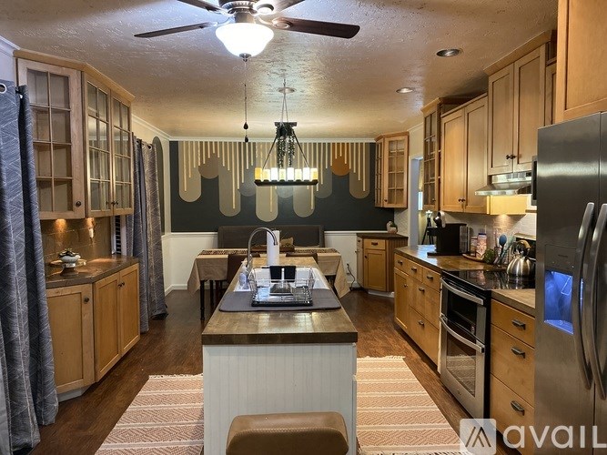 A kitchen with wooden cabinets and a large island in the middle.