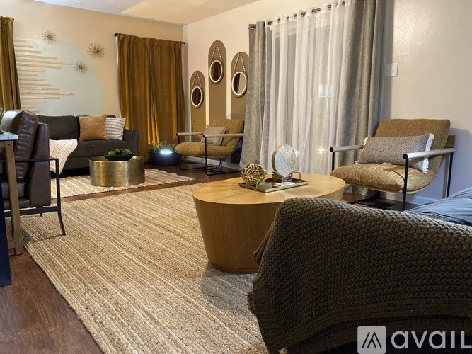 A living room with a sofa, armchairs, and a coffee table.