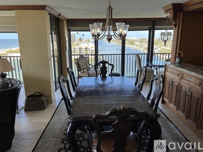 A dining room with a table set for six with a view of the ocean.