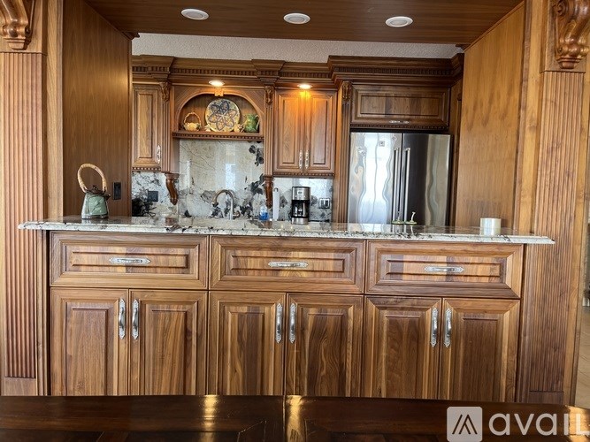 A kitchen with wooden cabinets and a marble countertop.