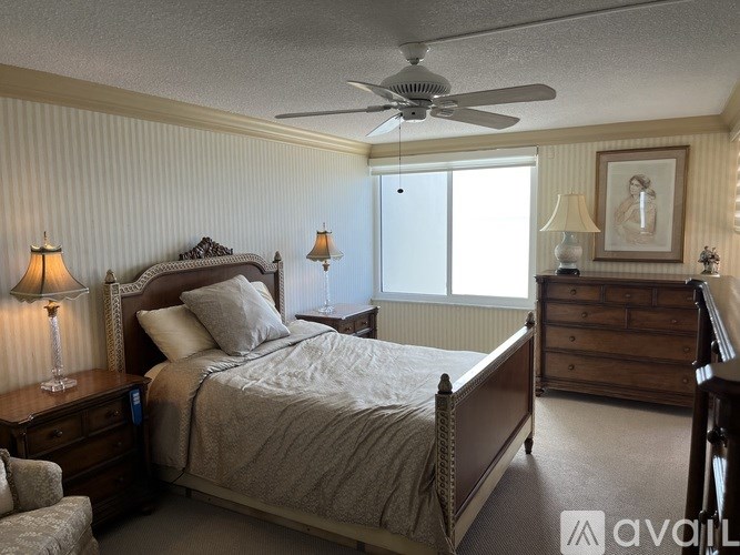 A bedroom with a bed, dresser, and window.
