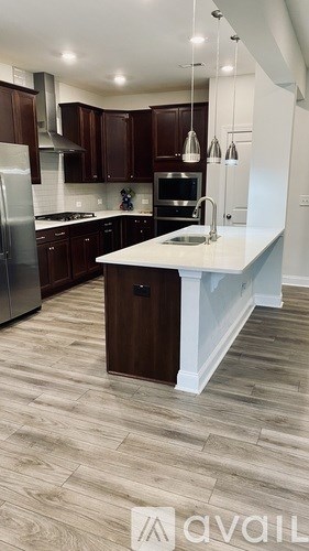 A kitchen with brown cabinets and a white island.