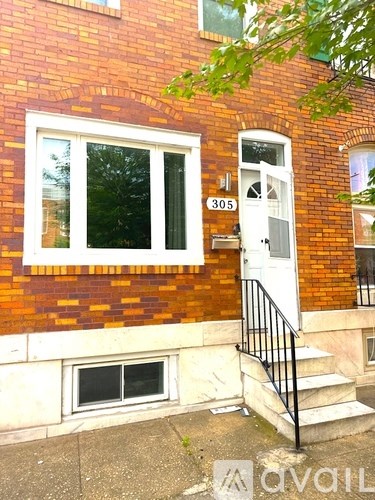 A red brick house with a white door and window.