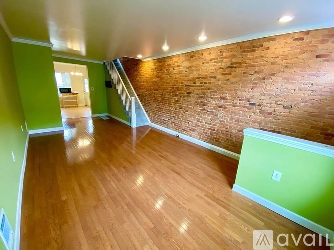 A room with wooden floors and a brick wall.