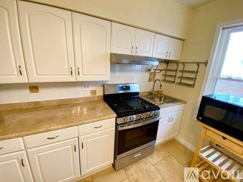 A kitchen with white cabinets and a black stove top.