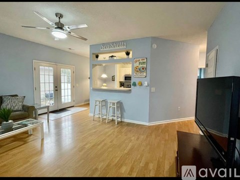 A living room with a television and a bar area.