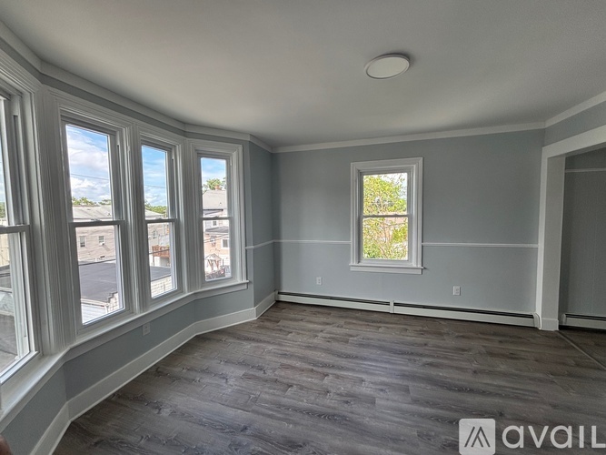A room with a window and a wooden floor.