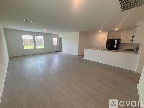A spacious room with a kitchenette and a window.