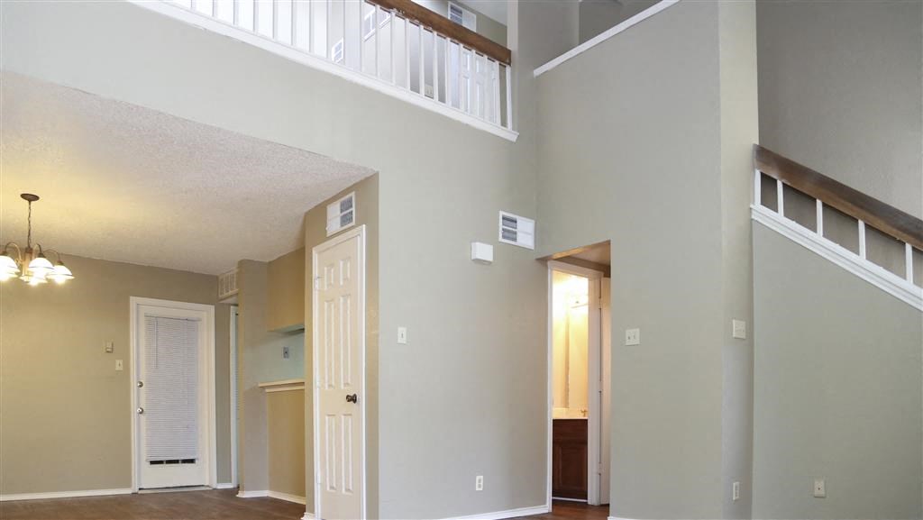 an empty room with a white door and a balcony