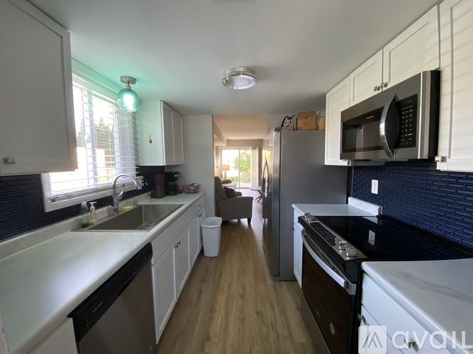 A kitchen with white cabinets and a black countertop.