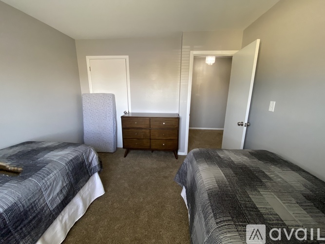 A bedroom with two beds and a dresser.