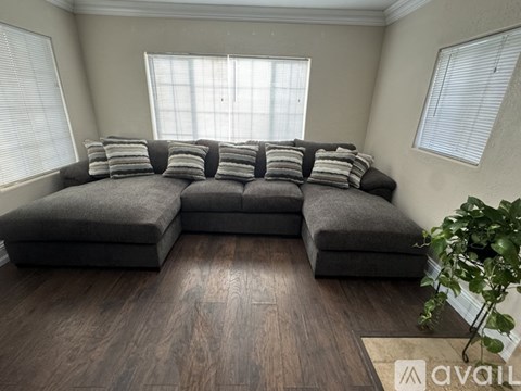 A grey sectional sofa with pillows in a living room.