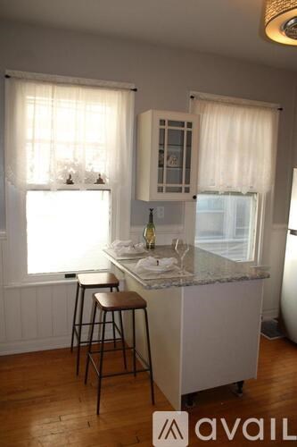 A kitchen with a white counter and two bar stools.