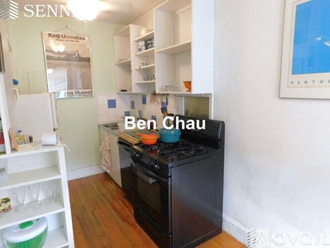 A kitchen with a black oven and a sign that says Ben Chau.