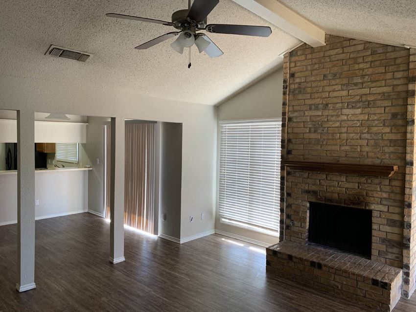a living room with a fireplace and a ceiling fan