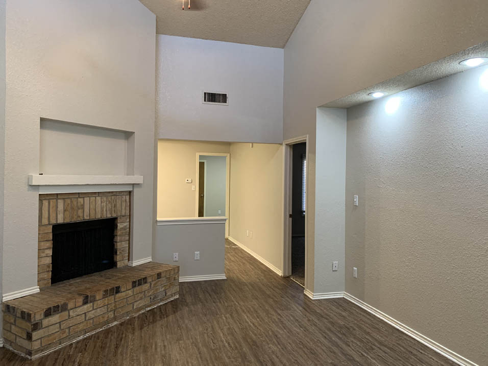 a living room with a fireplace and wooden floors