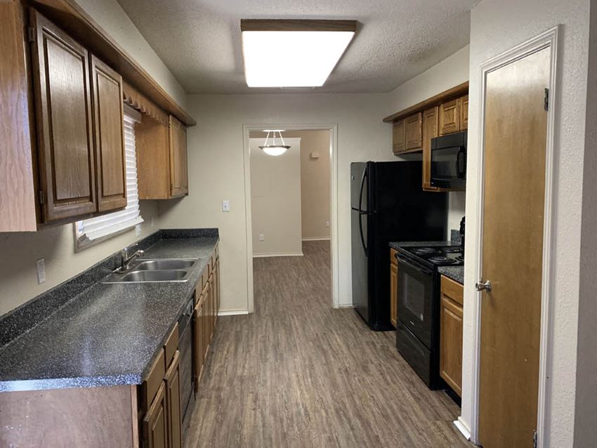 a kitchen with a sink and a black refrigerator
