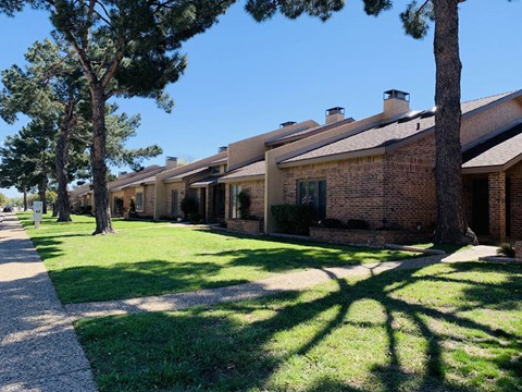 a row of houses with grass and trees