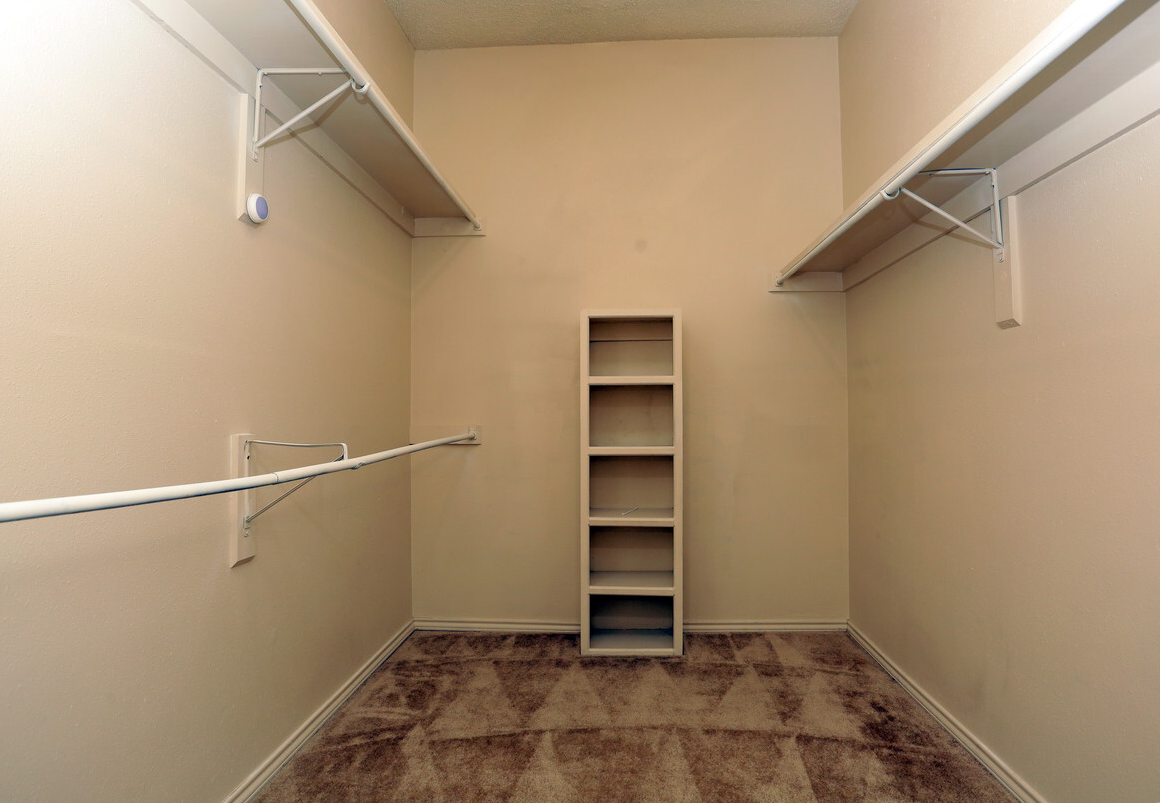 a room with a closet and shelves on the wall