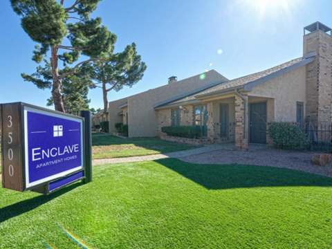 a house with a sign in the grass in front of it