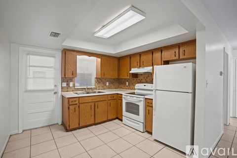 A kitchen with white appliances and wooden cabinets.