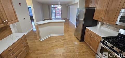 A kitchen with wooden cabinets and a black refrigerator.