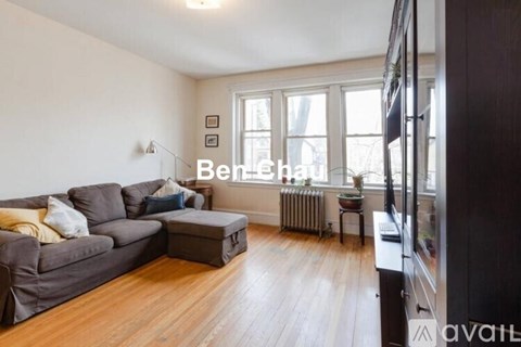 A living room with a grey couch and a wooden floor.