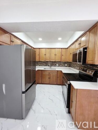 A kitchen with wooden cabinets and a marble countertop.
