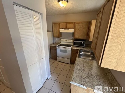 A kitchen with wooden cabinets and a granite countertop.