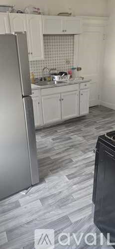 A kitchen with a refrigerator and a sink.